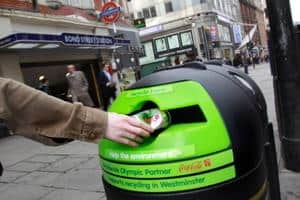 A can being dropped in one of the bins installed by Coca-Cola and Westminster city council in the West End