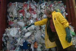 Carlos Minc, Brazilian environment minister, examines the waste materials in Brazil