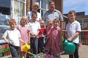 Teacher Angela Wallington and Eco's Jim Mason join proud pupils at Sylvan First School in their award-winning garden area