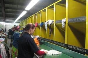 Used clothing is sorted by hand at Lawrence M Barry in East London