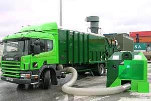 A Recresco truck collects plastic bottles from a bank using a vacuum