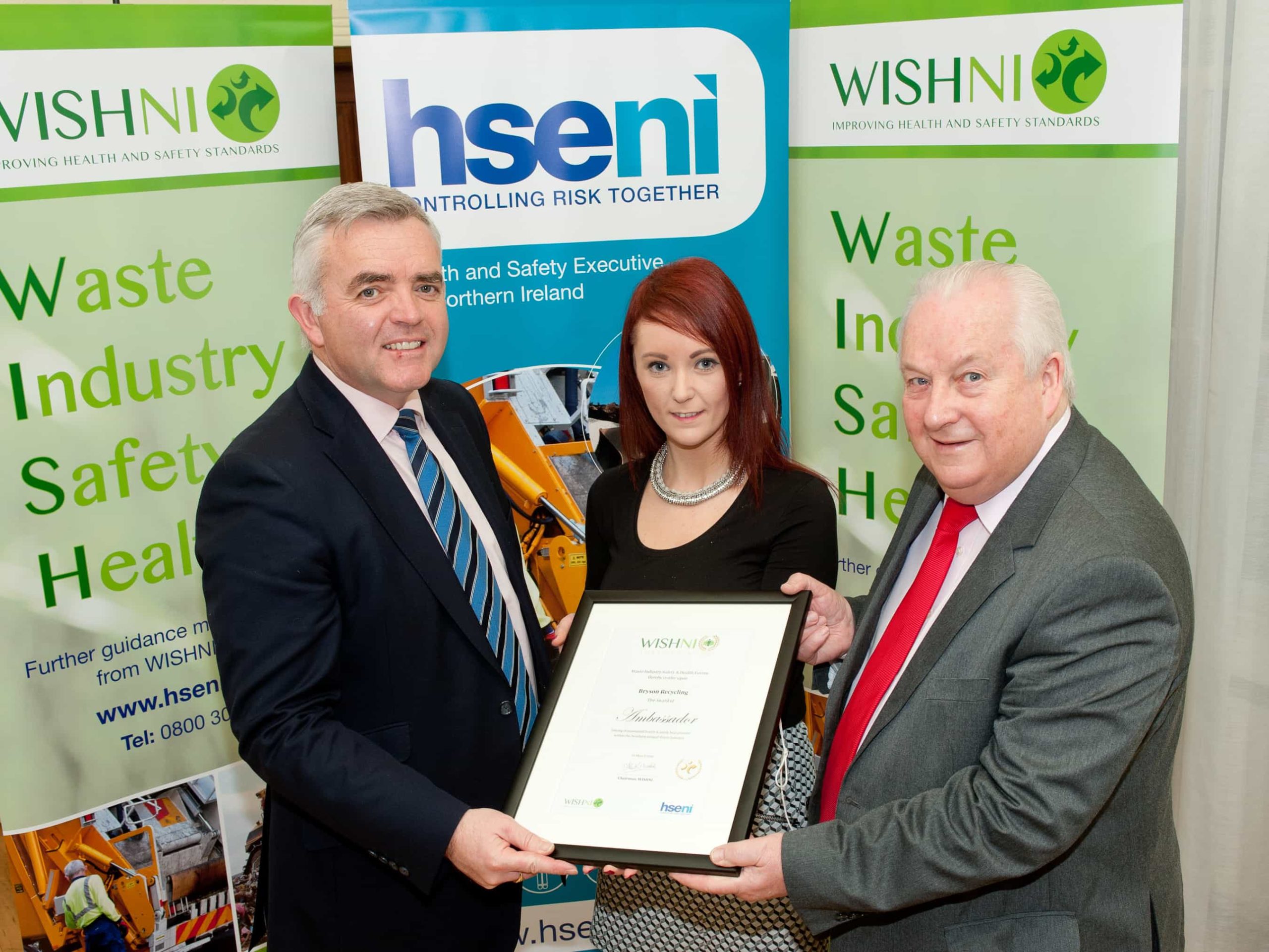 Danielle Crockford from Bryson Recycling receives WISH NI Ambassador 2016 Award for demonstrating health and safety best practise within the Northern Ireland Waste Management Industry from Enterprise Trade and Investment Minister Jonathan Bell (left) and Chair of WISH NI Alan Woodside OBE (right)